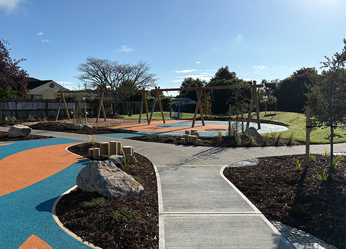 Timber swing set with basket swing and standard swing over blue and orange rubber surfacing