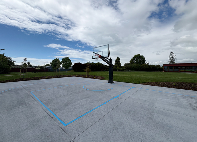 Outdoor basketball half court with hoop and painted court markings at Decks Reserve