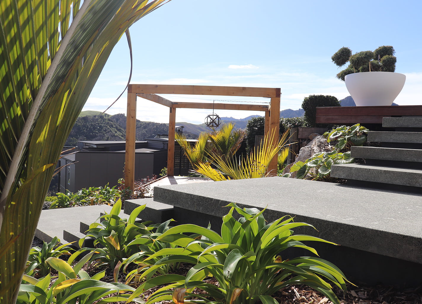 Tiered concrete steps with native planting and raised planter in Maitai Residence garden