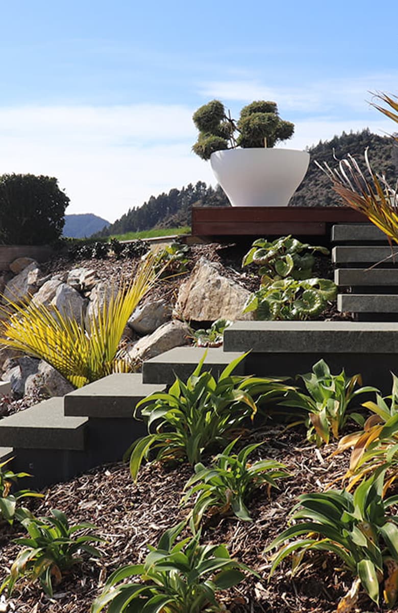 Timber pergola and large planter on elevated deck with panoramic city and bay views at Maitai Residence