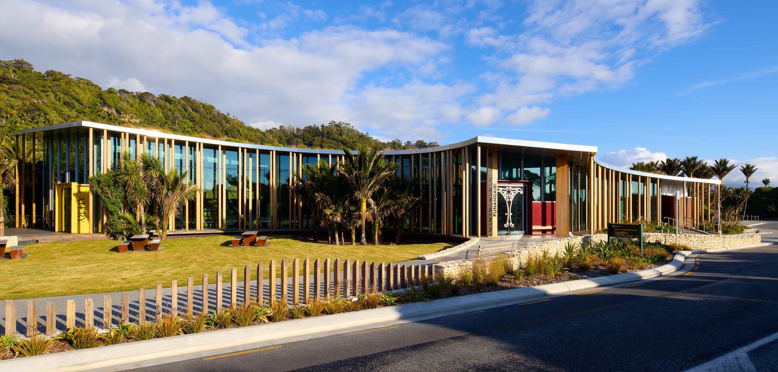 Elevated view showing the curved roof, central lawn courtyard, and surrounding landscape